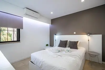 a bedroom with a large white bed with a window at BeGuest Aveiros Beach View Apartment in Albufeira