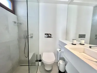 a white bathroom with a toilet and a shower at Vila Ruby - Private Pool by HD PROPERTIES in Vilamoura