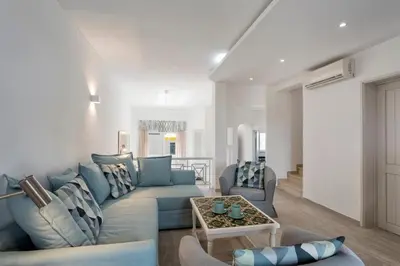 a living room with a blue couch and a table at Villa Isabel in Vale do Lobo