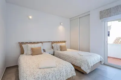 two beds in a room with a window at Villa Isabel in Vale do Lobo