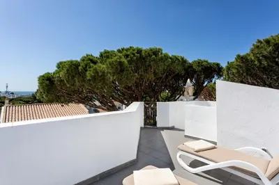 a patio with two chairs and a white fence at Villa Isabel in Vale do Lobo
