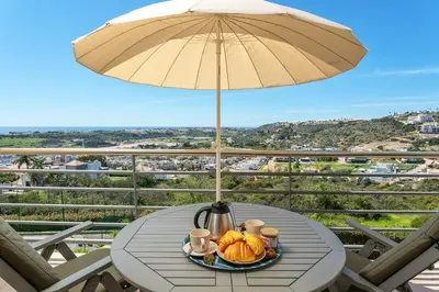a group of lawn chairs next to a swimming pool at BnB Homes Ocean View Apartment with relax Terrace, 2 Swimming pools & Tennis court in Albufeira