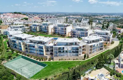 a cave on the beach with a boat in the water at BnB Homes Ocean View Apartment with relax Terrace, 2 Swimming pools & Tennis court in Albufeira
