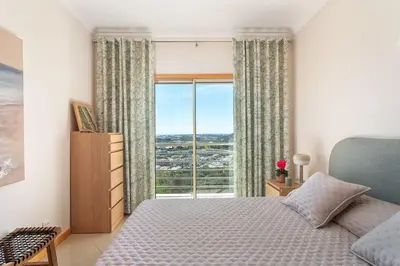 a living room with a couch and a flat screen tv at BnB Homes Ocean View Apartment with relax Terrace, 2 Swimming pools & Tennis court in Albufeira