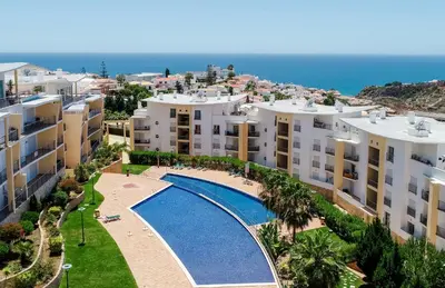 a bedroom with a bed and a large window at BnB Homes Ocean View Apartment with relax Terrace, 2 Swimming pools & Tennis court in Albufeira