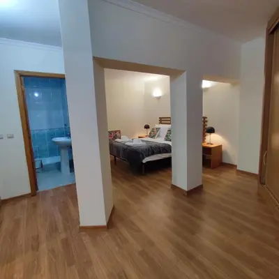 a bedroom with a bed and a desk in a room at Casa Alfarroba in Albufeira