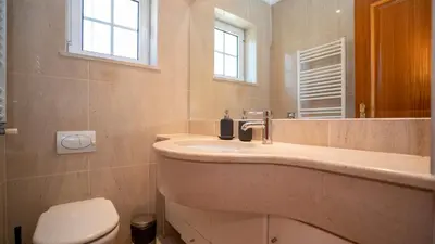 a bathroom with a sink and a toilet and a mirror at Amora Classic Villa in Vilamoura