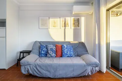 a blue couch with pillows on it in a room at Amendoeiras Family Apartment in Quarteira