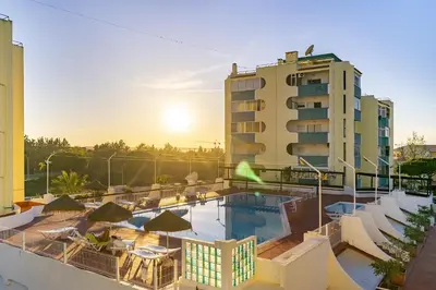 a hotel with a pool in front of a building at Amendoeiras Family Apartment in Quarteira