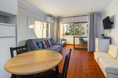 a living room with a table and a couch at Amendoeiras Family Apartment in Quarteira