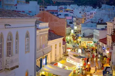a view of a city at night with people walking around at douceur d'algarve in Albufeira