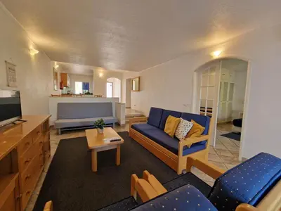 a living room with a blue couch and a tv at douceur d'algarve in Albufeira