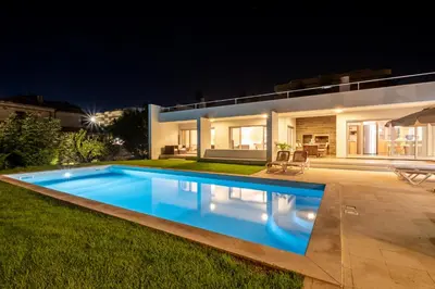 a swimming pool in front of a house at night at Villa L in Galé