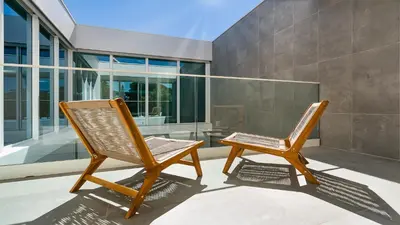 two chairs sitting on a patio with a building at Villa Serenity- CleverDetails, Central Vilamoura, Sleeps 4 adults and 2 children, located in the center in Vilamoura
