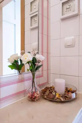 a vase with flowers and a candle on a table at Casa Dos Reis - Albufeira, Center in Albufeira