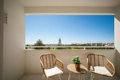 two chairs and a table on a balcony with a window at Casa Dos Reis - Albufeira, Center in Albufeira