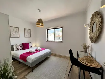 a bedroom with a bed and a table and a window at Albufeira Design by Homing in Albufeira