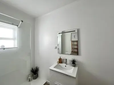 a white bathroom with a sink and a mirror at Albufeira Design by Homing in Albufeira