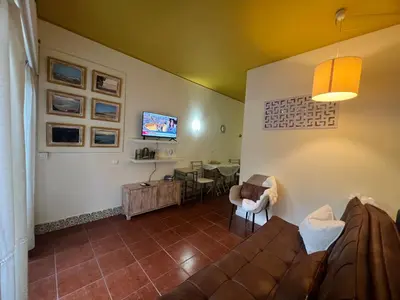 a living room with a brown couch and a chair at Casa Girassol Old Town in Albufeira