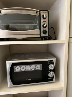 a microwave and a toaster oven on a shelf at Casa Girassol Old Town in Albufeira