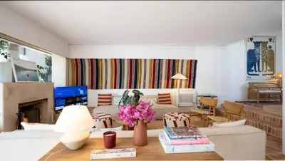 a living room with a couch and a table with flowers at Quinta do Lago, Victory Village N 63 in Almancil