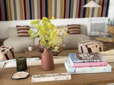 a living room with a table with a vase and books at Quinta do Lago, Victory Village N 63 in Almancil