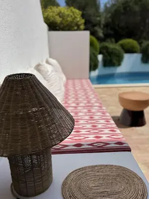 a wicker bench with a table in front at Quinta do Lago, Victory Village N 63 in Almancil