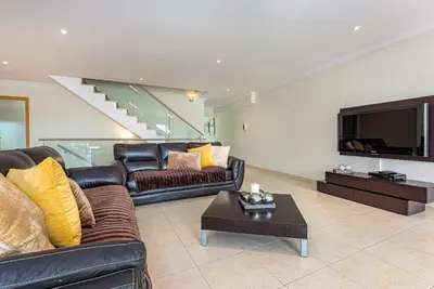 a living room with a leather couch and a tv at Villa Seashell in Albufeira