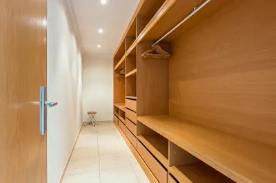 a walk in closet with wooden shelves and a door at Villa Seashell in Albufeira