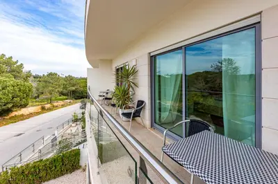 a balcony with a table and chairs on a building at Villa Seashell in Albufeira