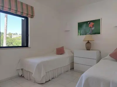 a bedroom with two beds and a window at Ancão Beach Apartment in Almancil