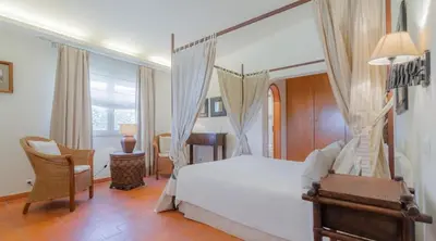 a bedroom with a bed and a desk and a chair at Villa Prado - Beautiful beachfront villa in Albufeira
