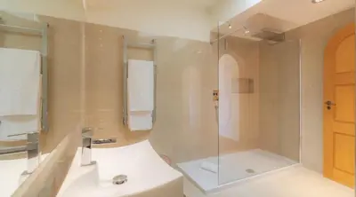a bathroom with a shower and a white sink at Villa Prado - Beautiful beachfront villa in Albufeira