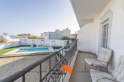 a kitchen with black cabinets and a table with a bottle of wine at #108 T0 Coronel Águas by Home Holidays in Albufeira