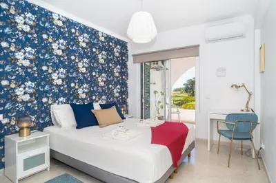 a bedroom with a bed with a blue floral wallpaper at Magnífico apartamento perto da praia in Albufeira