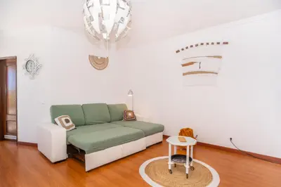 a living room with a green couch and a table at Magnífico apartamento perto da praia in Albufeira