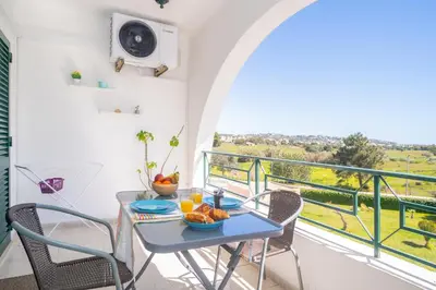 a table and chairs on a balcony with a view at Magnífico apartamento perto da praia in Albufeira