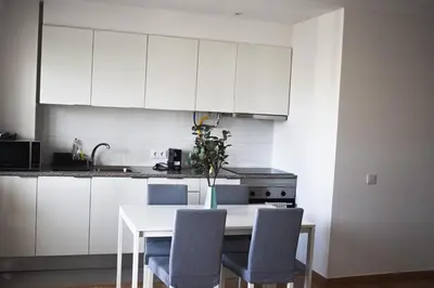 a kitchen with white cabinets and a table with chairs at GrowIN Stay Downtown in Faro