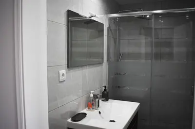 a bathroom with a sink and a shower with a mirror at GrowIN Stay Downtown in Faro