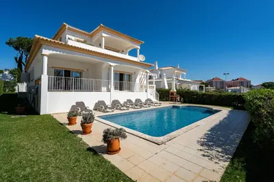 a villa with a swimming pool in front of a house at Villa White Cottage by SAPvillas in Vilamoura