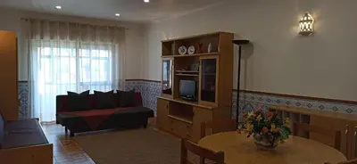a living room with a couch and a television at Albufeira Beach - Tranquilidade junto à praia e ao centro! in Albufeira