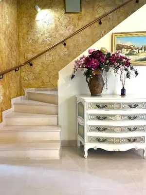a staircase with a dresser with a vase of flowers on it at PARADISE ON THE BEACH in Albufeira