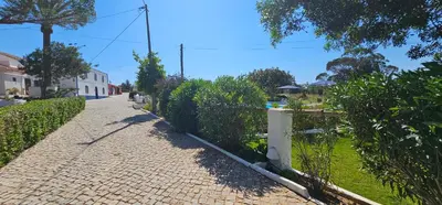 a brick road with a fence next to a yard at Quinta do Lagar - 10 in Albufeira