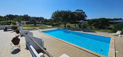 a swimming pool with blue water in a yard at Quinta do Lagar - 10 in Albufeira