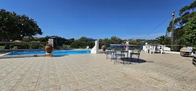 a patio with a table and chairs next to a pool at Quinta do Lagar - 10 in Albufeira