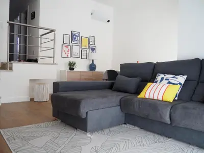 a grey couch in a living room with a rug at Charming V2 next to ocean, golf & natural reserve in Albufeira