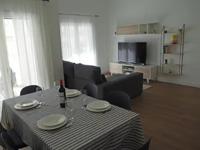a living room with a table with a bottle of wine at Charming V2 next to ocean, golf & natural reserve in Albufeira