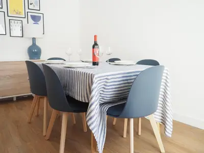 a dining room table with blue chairs and a table cloth at Charming V2 next to ocean, golf & natural reserve in Albufeira