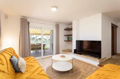 a living room with a couch and a tv at The Albufeira Concierge - Villa Pool & Tennis in Albufeira
