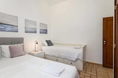 a white bedroom with two beds and a lamp at The Albufeira Concierge - Villa Pool & Tennis in Albufeira
